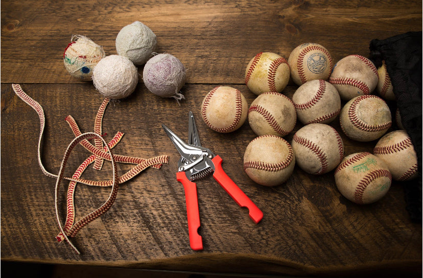 The Anchor Original Artwork - Made from Actual Used Baseballs, featuring used baseballs and crafting tools on a wooden table.