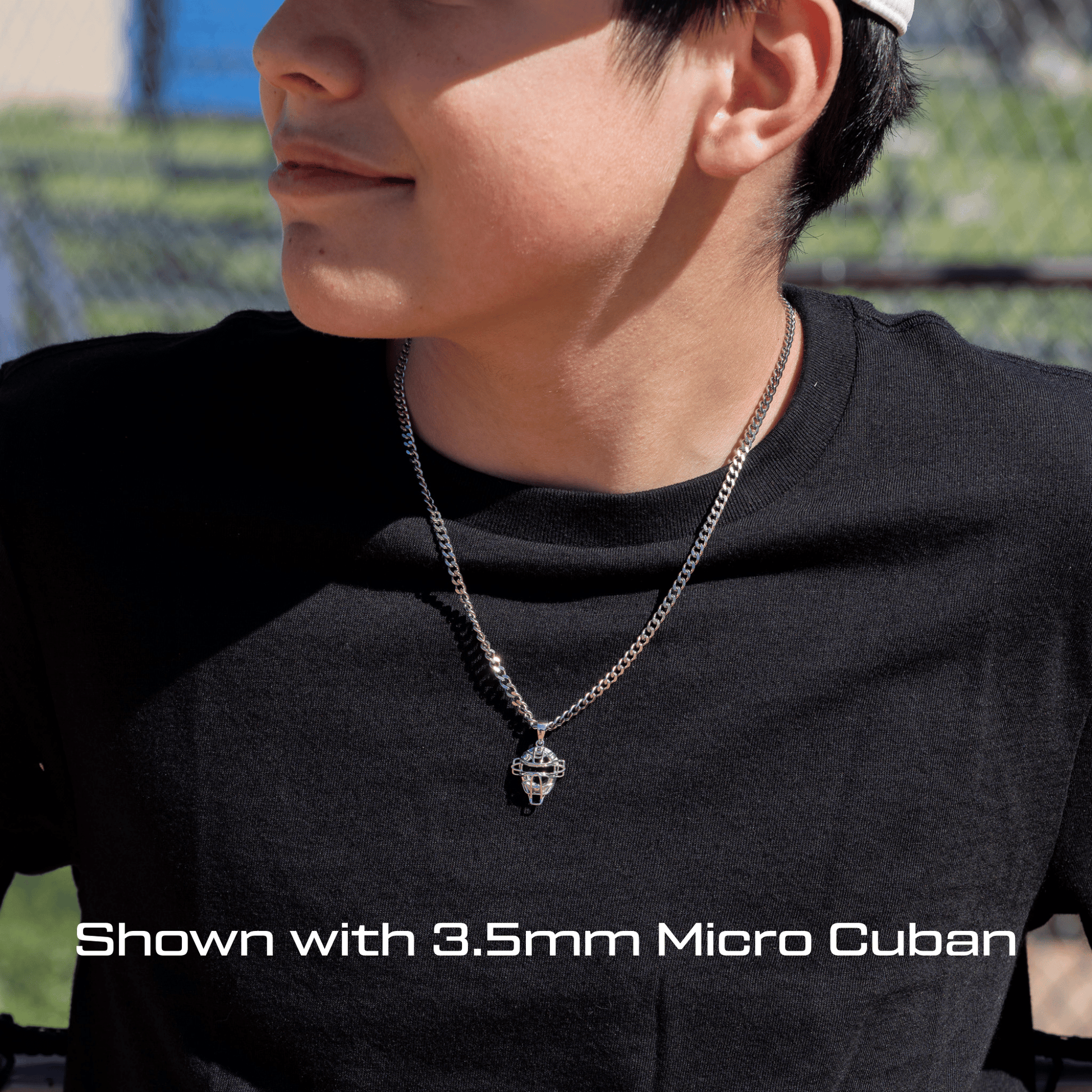 Person wearing a All In Faith Youth baseball catchers mask necklace in silver