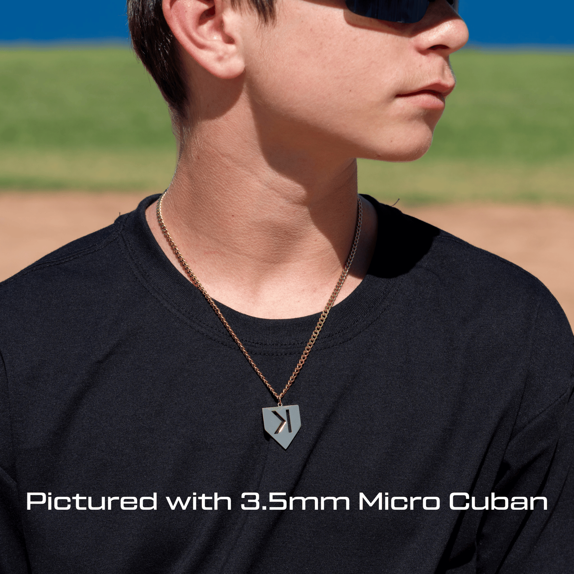 Person wearing a All In Faith backward "K" Strikeout home pate necklace on a sports field
