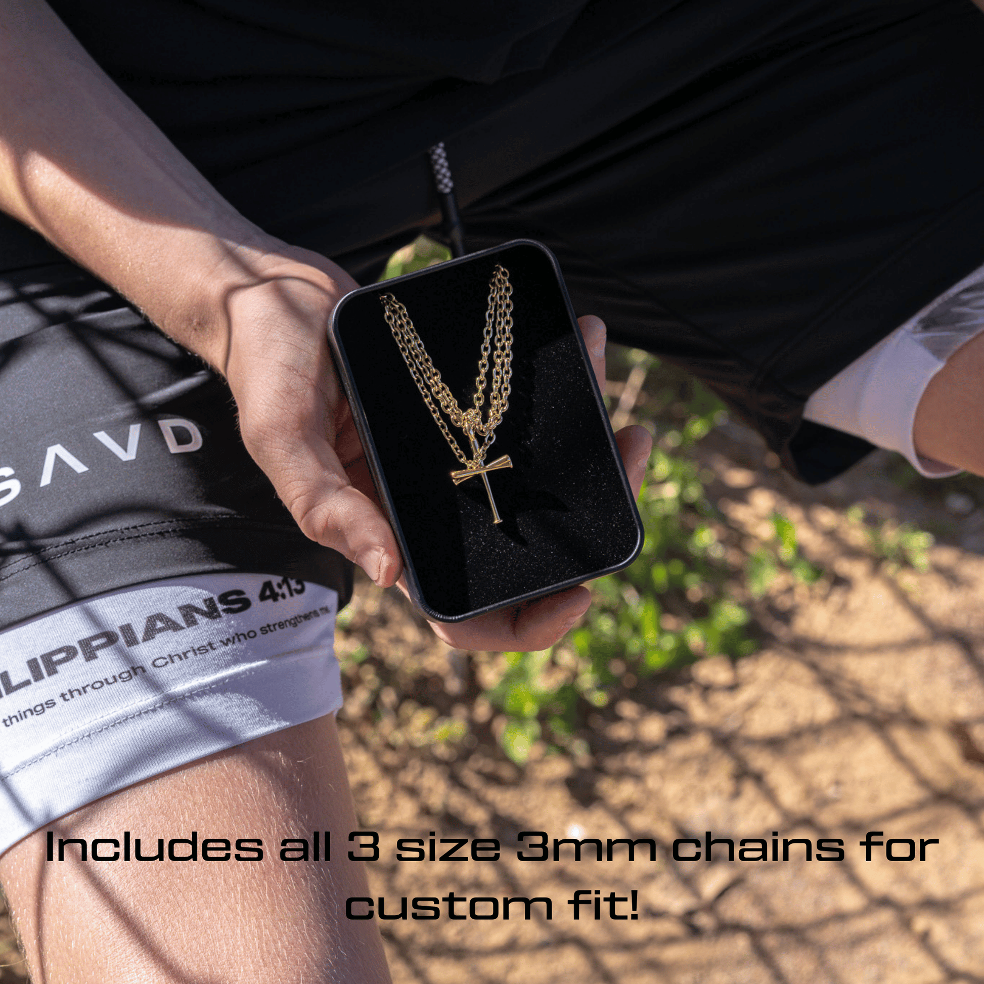 Person holding a black box with 3 gold chains and all in faith original baseball cross necklace