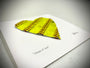 Softball Heart Artwork titled “Seams of Love” with yellow leather seams on a heart shaped design.