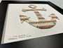The Anchor Original Artwork - Made from Actual Used Baseballs framed in black, featuring a baseball stitch anchor design.