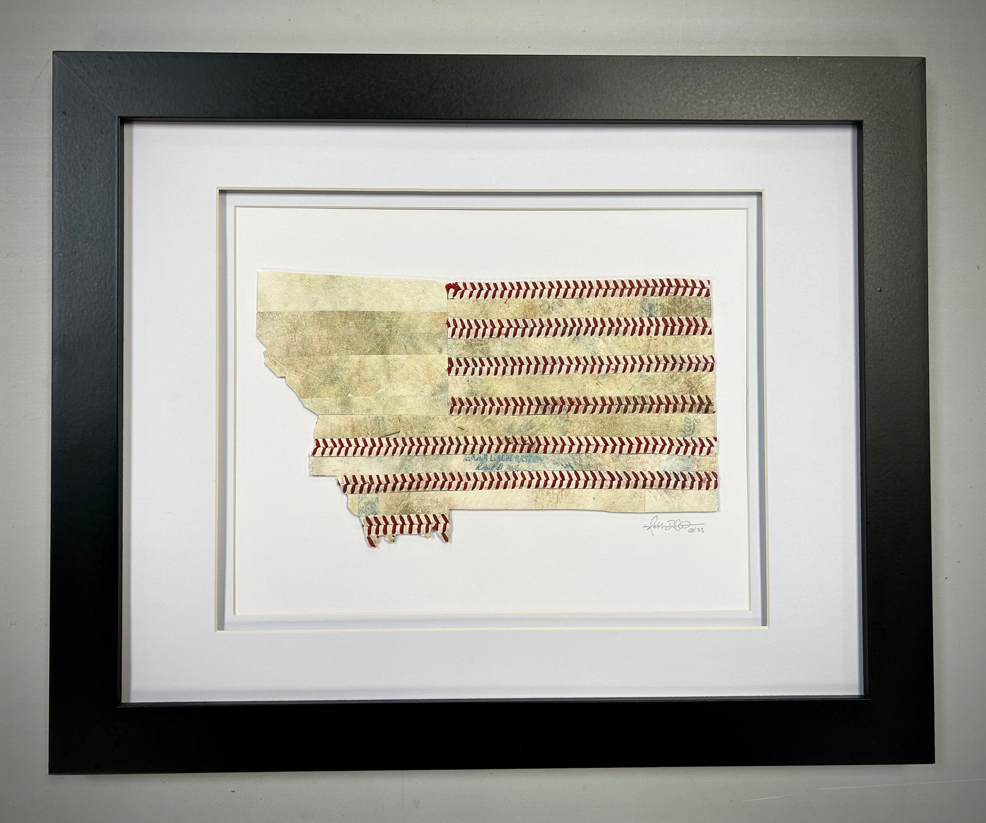 Montana Original Baseball Artwork - made from used baseballs displayed in a black frame with red stitching details.