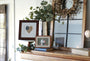 Decorative living room shelf featuring America's Love Original Artwork, framed photos, plants, and a rustic mirror.