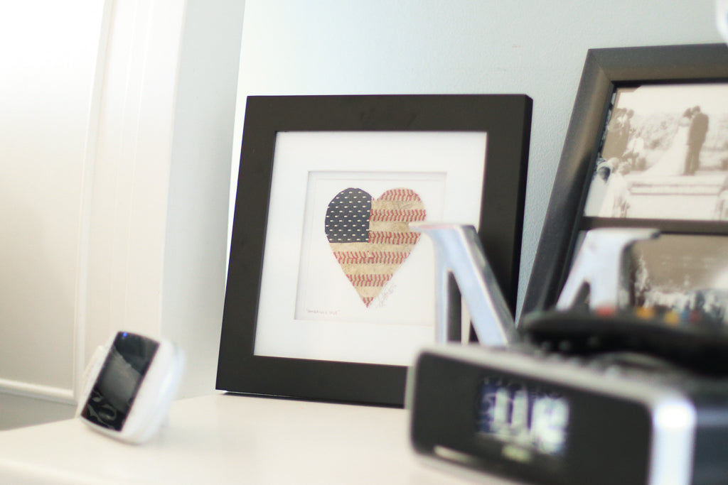 Framed "America's Love" Original Artwork showcasing a heart with American Flag design on a table.