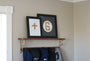 The Baseball Cross - Original Artwork Made from Actual Used Baseballs displayed on a shelf with hats below.