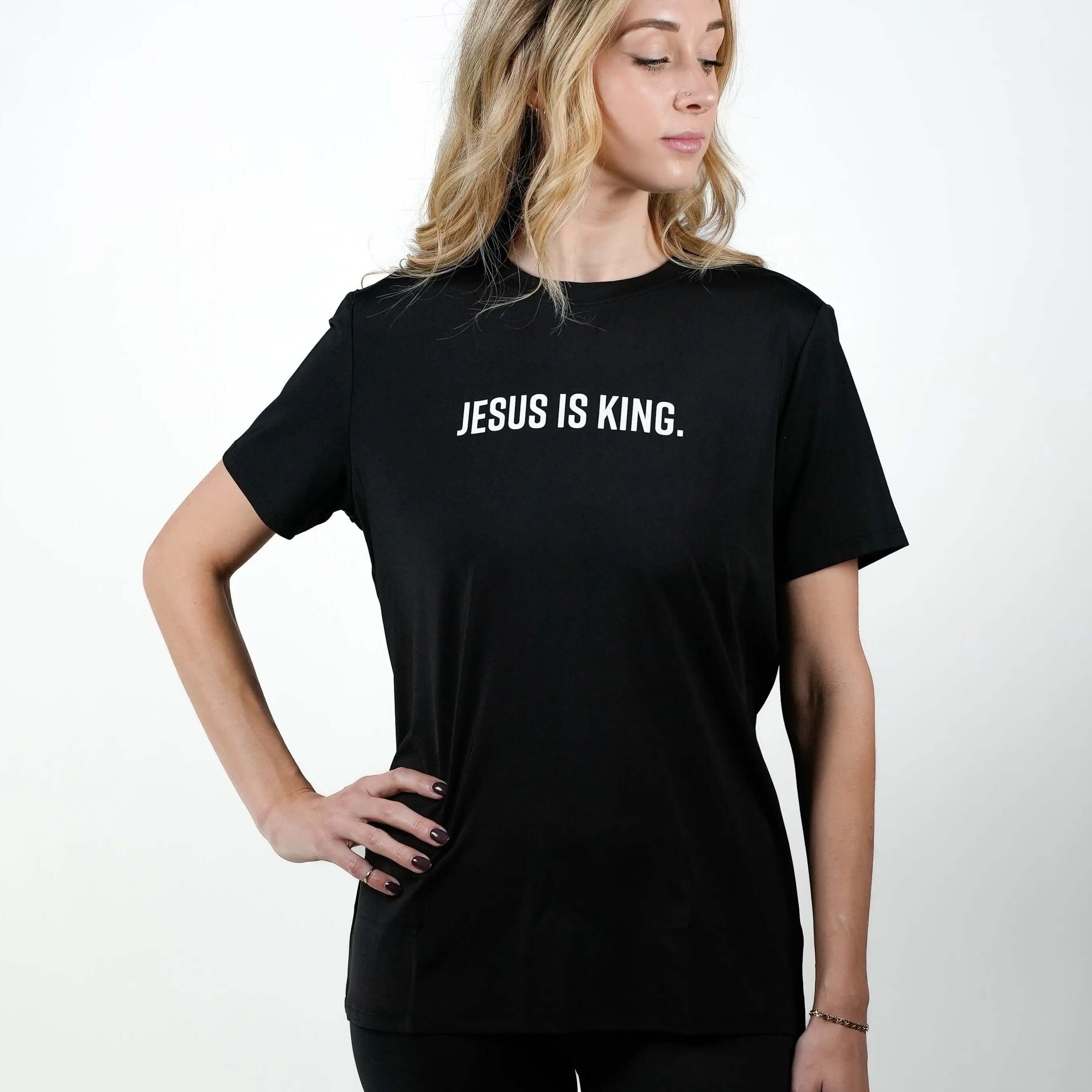 HolStrength female model wearing the black Jesus Is King Christian performance tee, front view