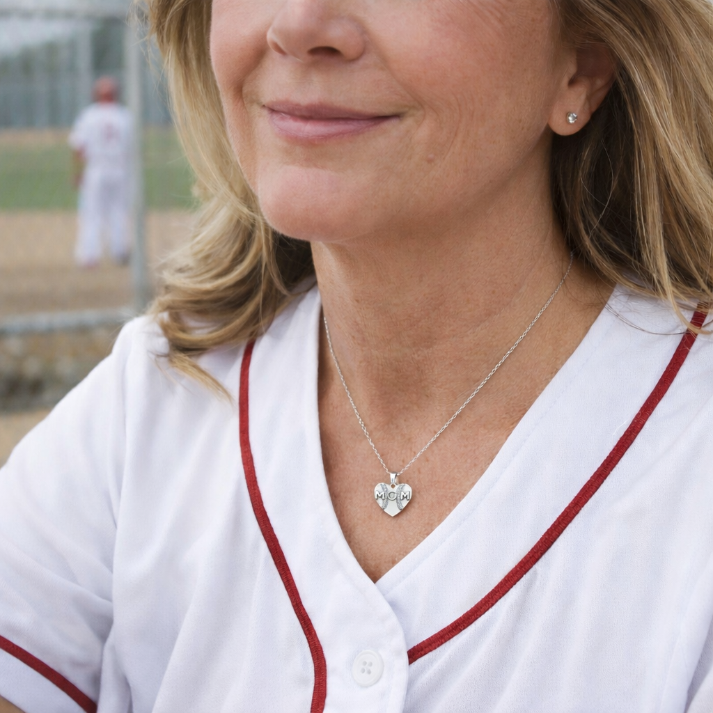 mother with a silver heart shaped pendant with baseball seams and mom written on the pendant