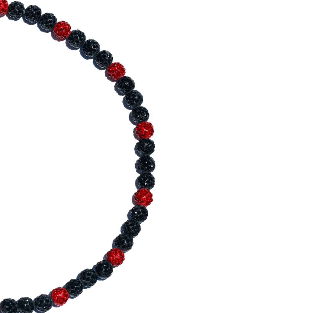 black and red iced out necklace on white background