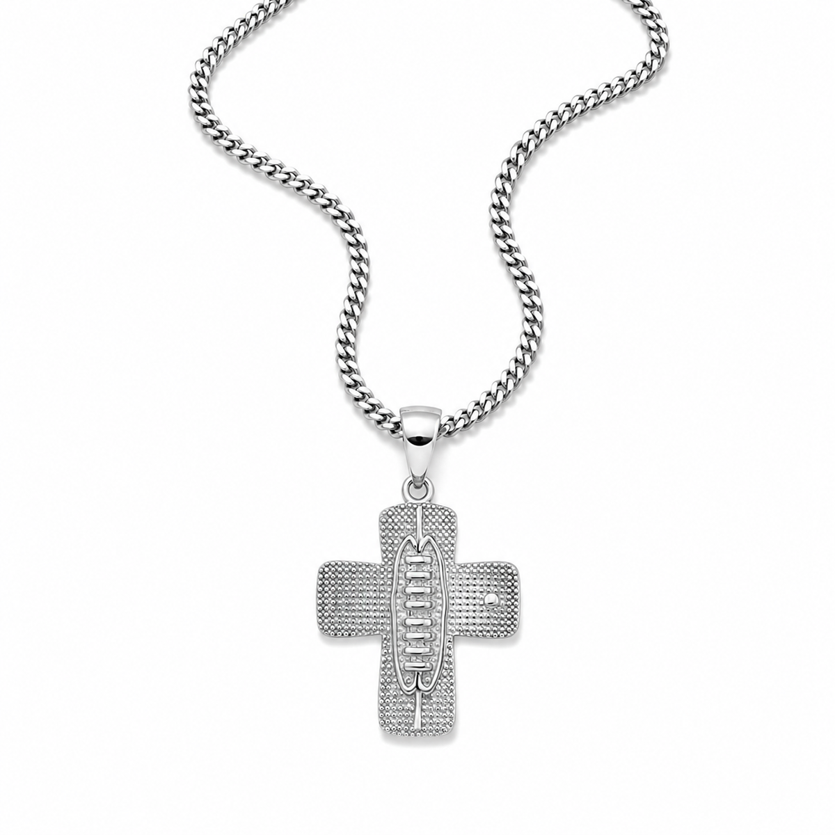 A silver cross pendant necklace with a textured, pave-set design and the word 'JESUS' in the center, hanging from a silver curb chain against a plain white background.