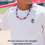 baseball player wearing a white shirt with a logo and a colorful beaded necklace, with a blurred background.