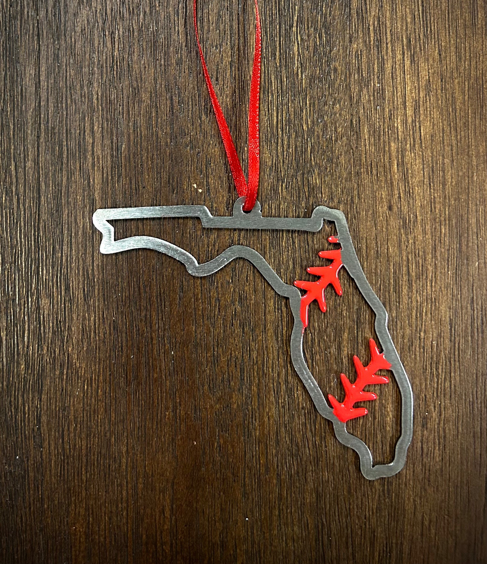 Florida Steel Baseball Christmas Ornament with red stitching, laser cut from steel, hanging with ribbon.