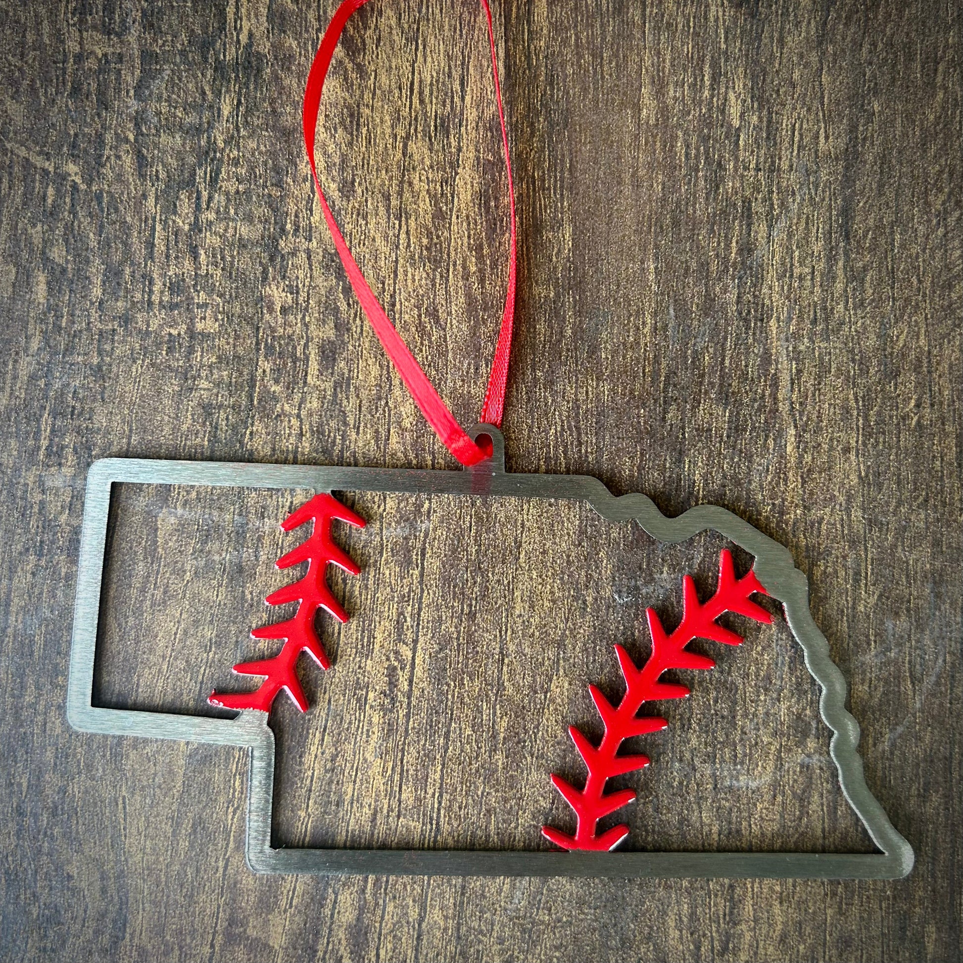 Nebraska Steel Baseball Christmas Ornament featuring a laser cut design with baseball stitching and red accents.