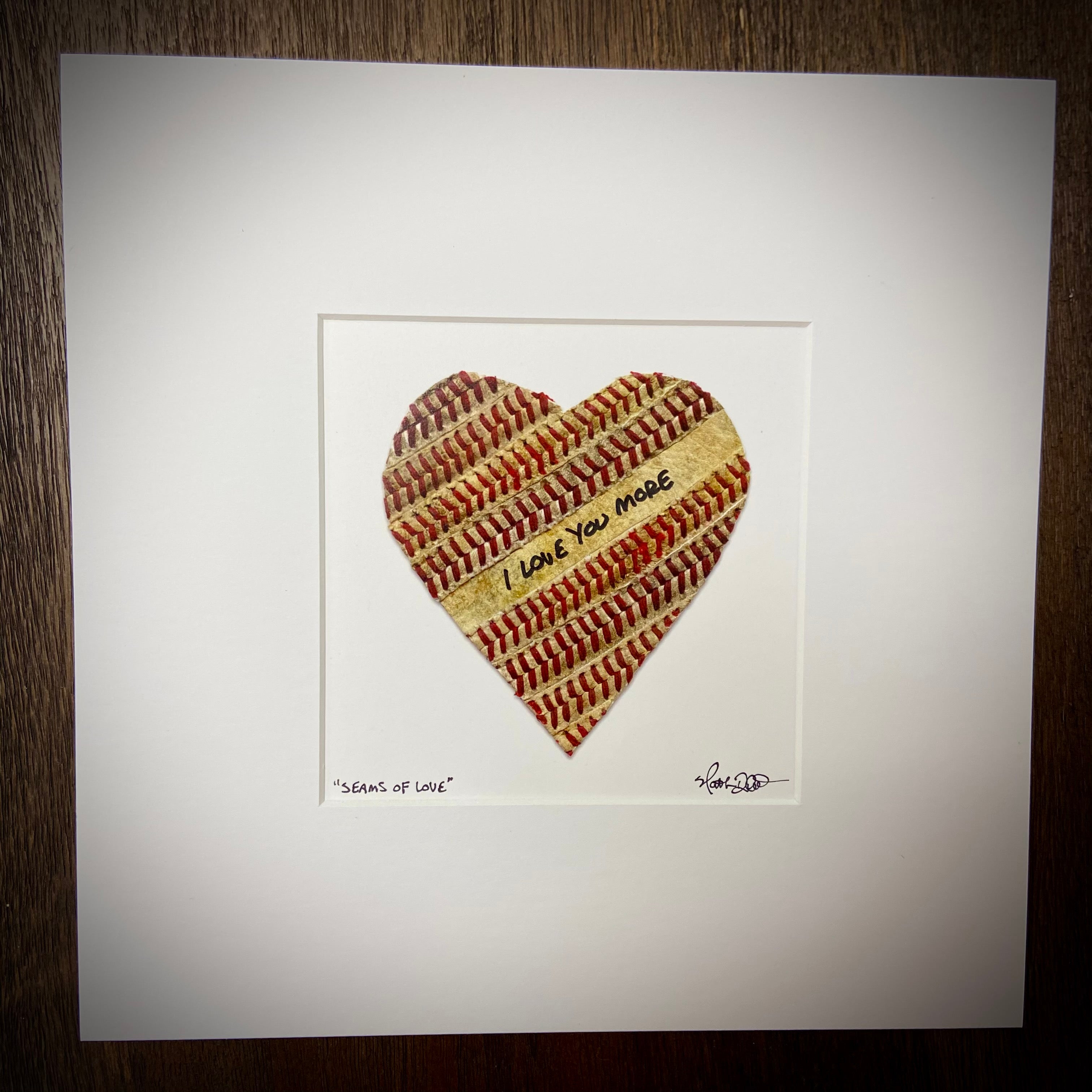 Customizable Baseball Heart Print in 10x10 White Matting featuring a heart made from baseball materials, inscribed with 'I Love You More'.