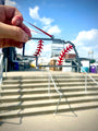 Nebraska Steel Baseball Christmas Ornament held outdoors, showcasing its unique design and vibrant colors.