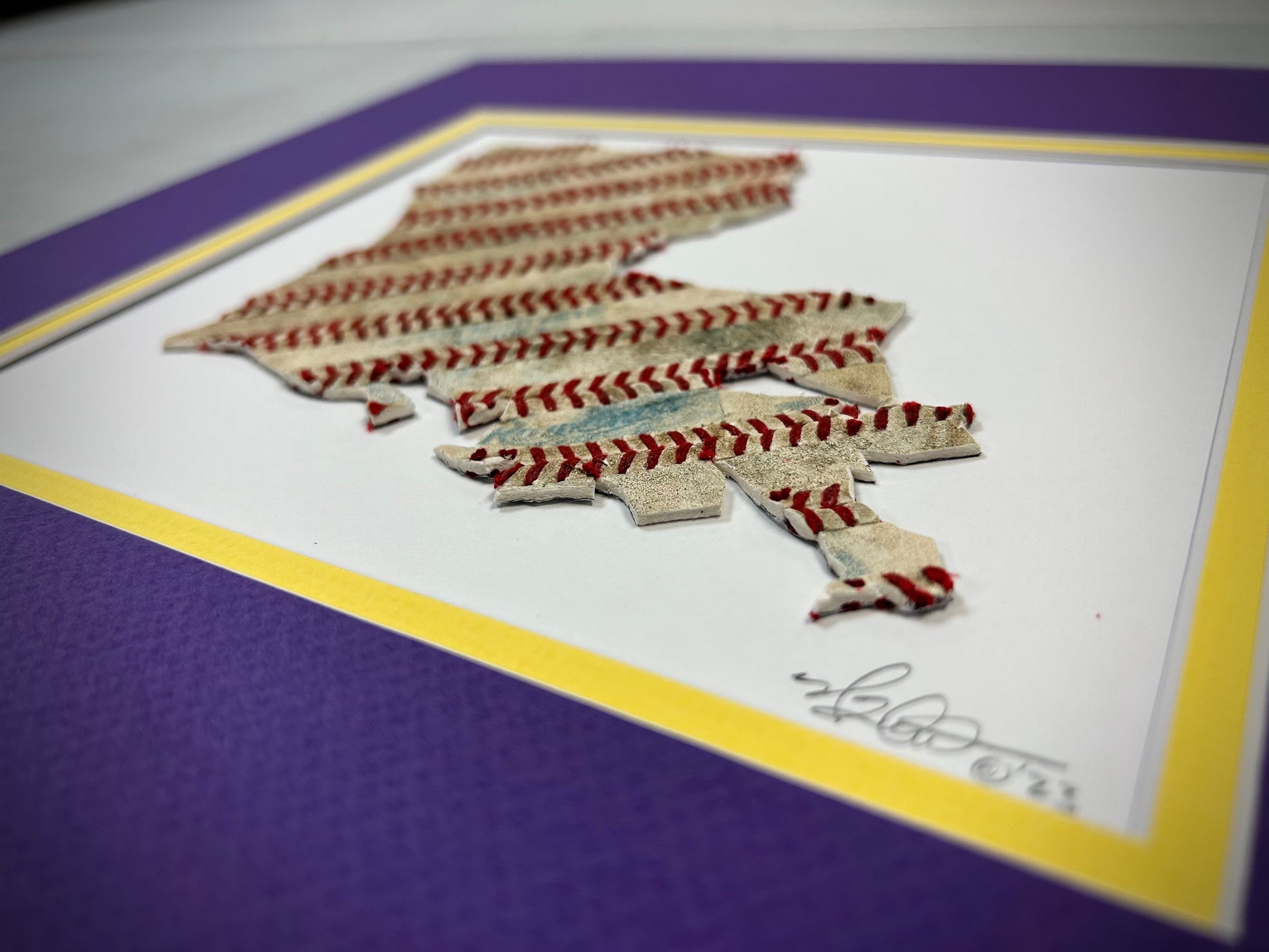 Custom State Artwork - Louisiana made from used baseballs, featuring a unique design with baseball stitching on a colorful mat.