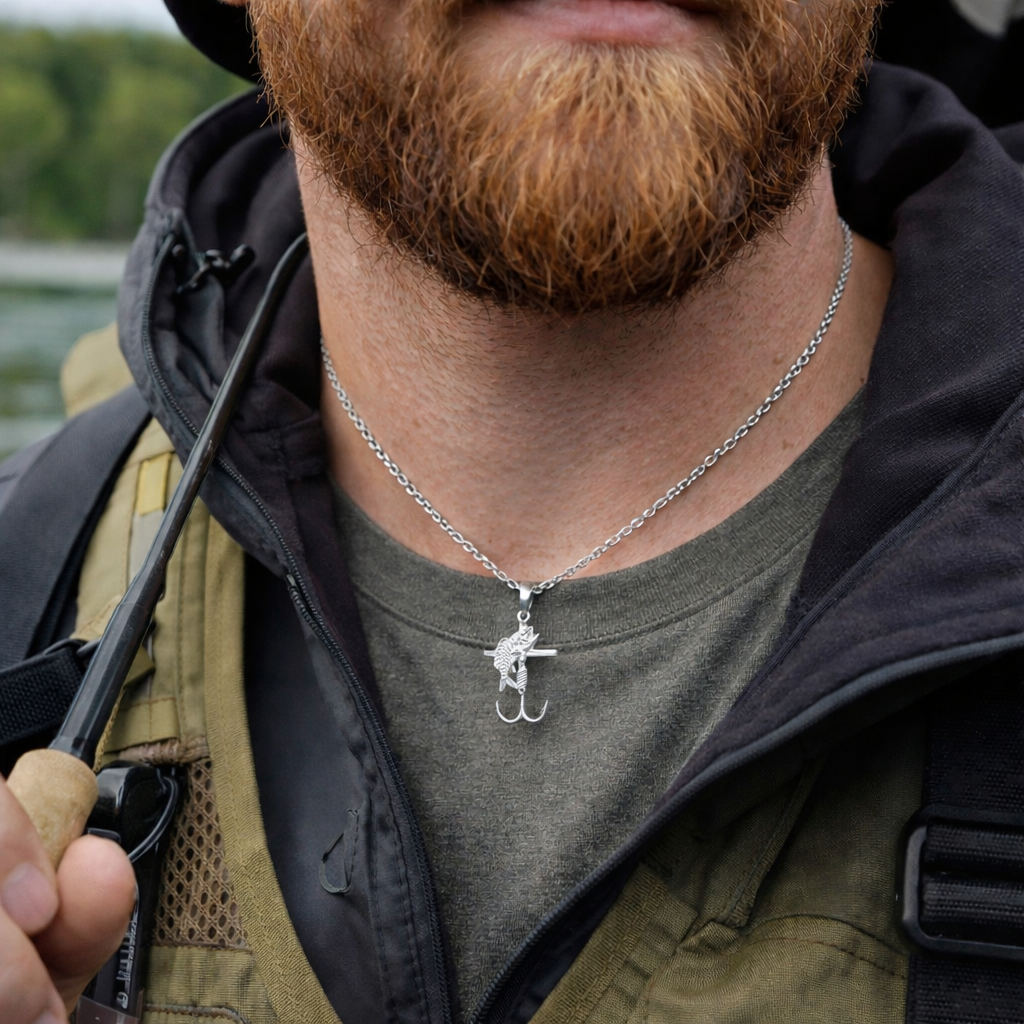 Man wearing a necklace with a fish hook pendant outdoors